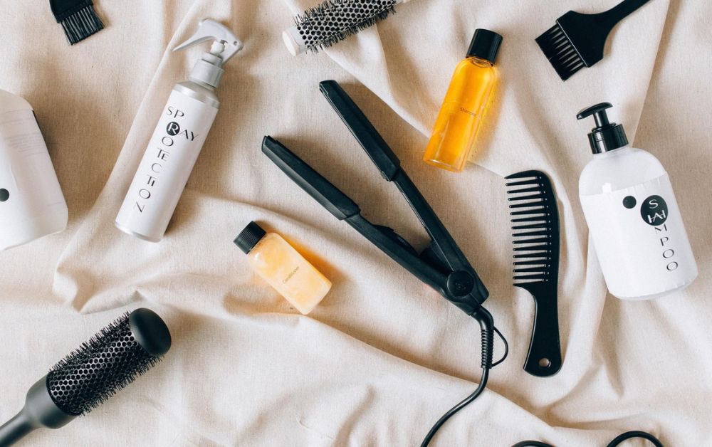 Flat lay of hair care products for colored hair shampoo, conditioner, heat protectant, brush