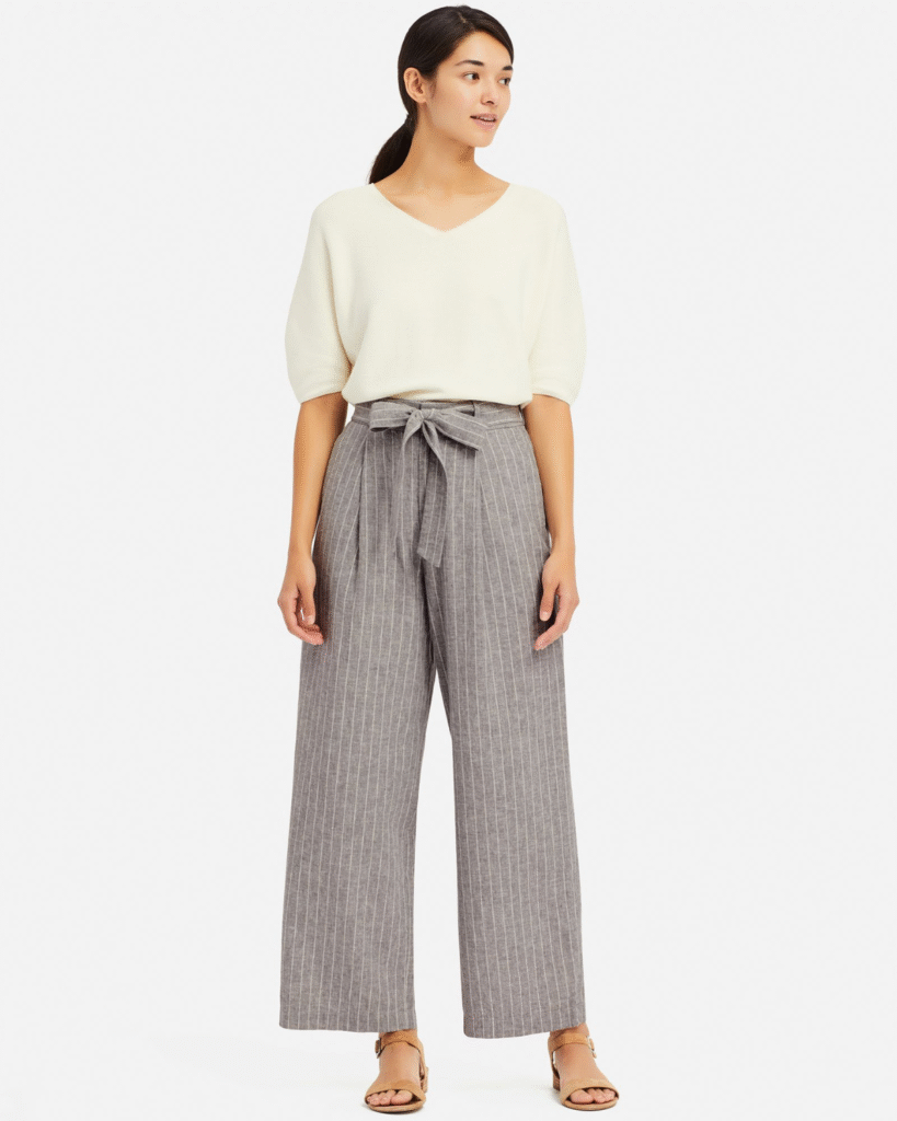 Woman High-waisted wide-leg pants with a tucked-in blouse and heels.